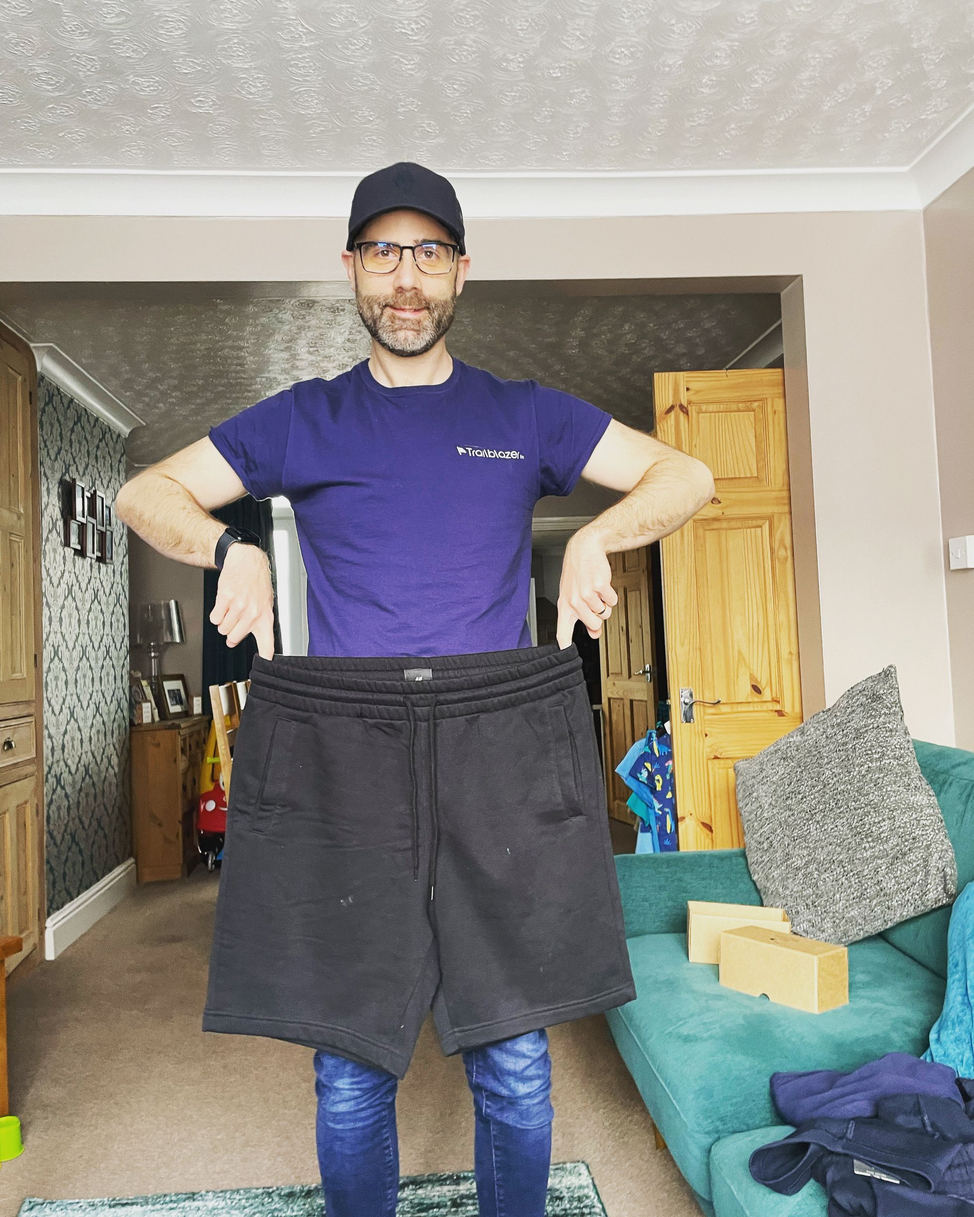 An image of Lee holding up his old shorts which are far too large for him now!